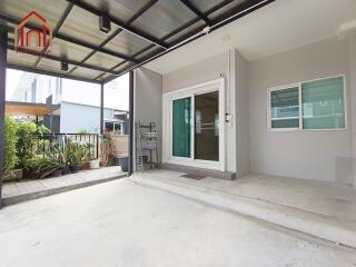 Covered patio area with sliding glass door and potted plants