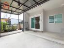 Covered patio area with sliding glass door and potted plants