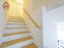 Staircase with wooden steps and white walls leading to upper floor