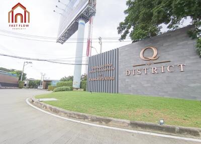 Entrance of Q District with signage and greenery