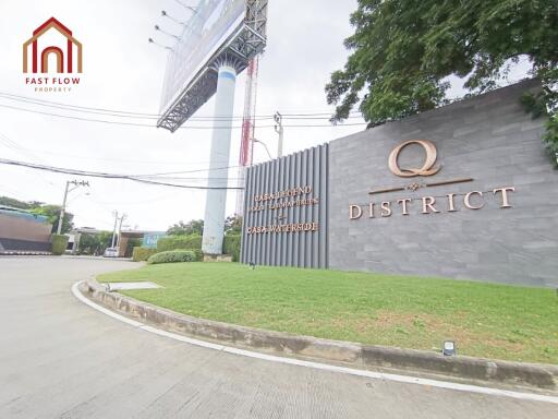 Entrance of Q District with signage and greenery