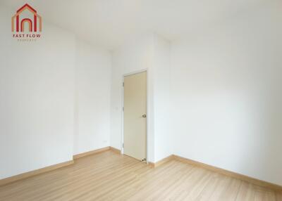 Empty bedroom with wooden flooring and white walls