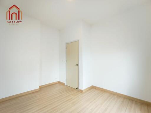 Empty bedroom with wooden flooring and white walls