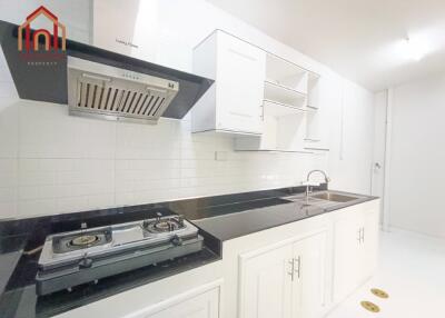 Modern kitchen with stove, range hood, and sink