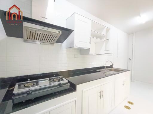 Modern kitchen with stove, range hood, and sink