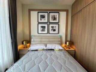 Modern bedroom with double bed, artwork, and bedside tables