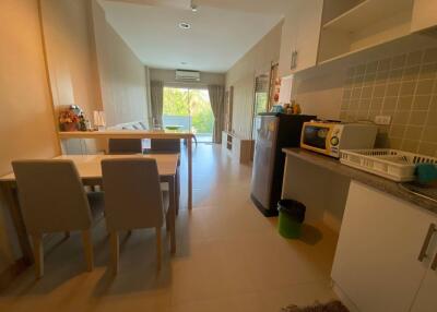 Photo of a kitchen and dining area with a view of the living space in the background