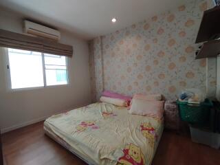 Cozy bedroom with floral wallpaper and a window