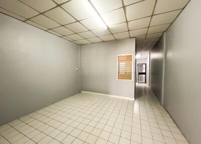 Empty room with tiled flooring and fluorescent lighting