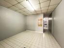 Empty room with tiled flooring and fluorescent lighting