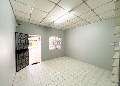 Spacious living room with tiled flooring and iron door