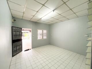 Spacious living room with tiled flooring and iron door