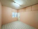 Empty bedroom with tile flooring and a window