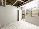 An empty room with tiled flooring, a door, and a window with metal bars.