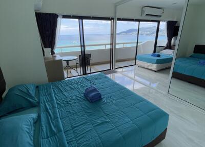 Modern bedroom with large window and ocean view