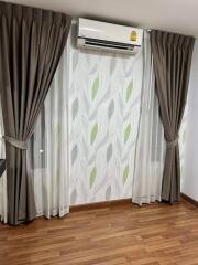 Living room with air conditioner, curtains, and hardwood floor