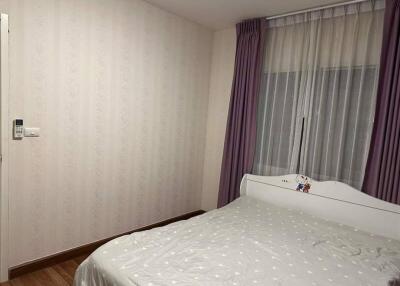 Cozy bedroom with a white bed and purple curtains