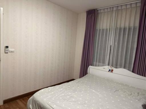 Cozy bedroom with a white bed and purple curtains