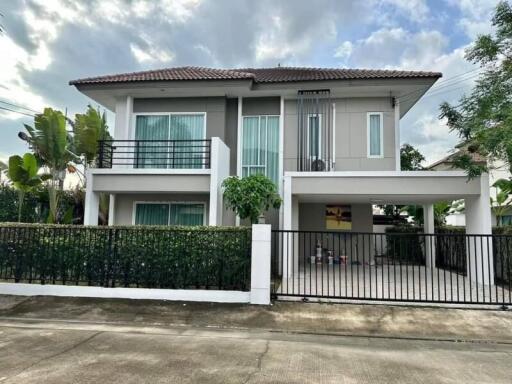 Two-story house with a tiled roof and gated driveway