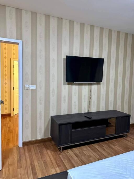 Bedroom with wall-mounted television and media console