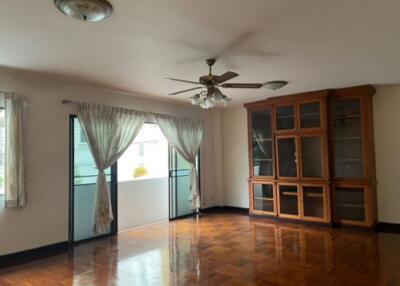 Spacious living room with wooden flooring and glass door cabinet