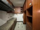 A kitchen with wooden cabinets, granite countertops, and tiled walls.