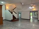 Spacious living room with staircase and large windows