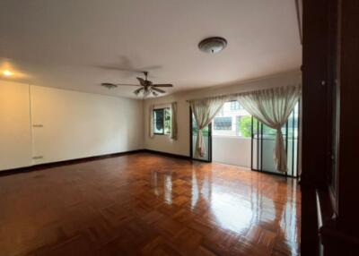 Spacious living room with wooden flooring and ample natural light