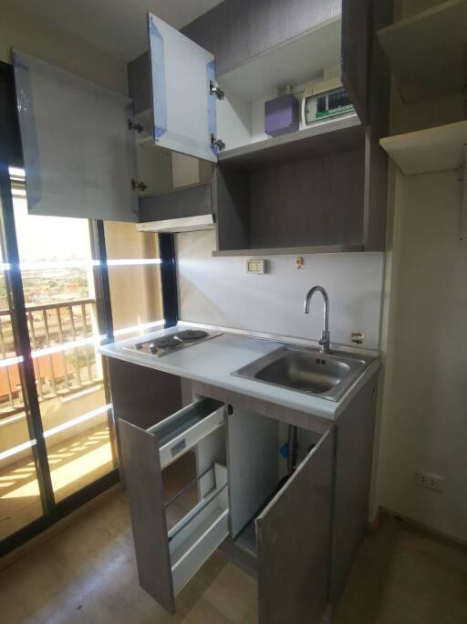 Compact kitchen with open cabinetry and a small sink