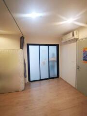 Empty bedroom with frosted glass sliding door and air conditioner.