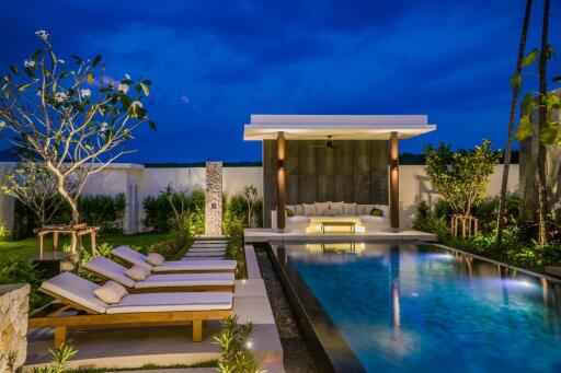 Luxurious outdoor pool area with lounge chairs and covered seating space