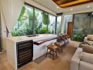 Modern kitchen with large windows, breakfast bar, and adjacent living area.