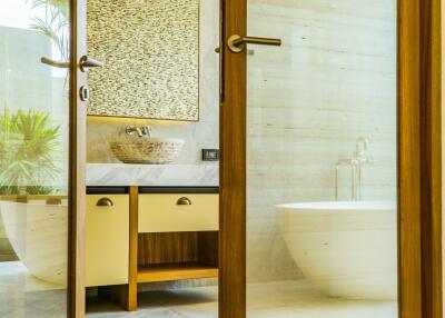 Modern bathroom with wooden accents, a vessel sink, and a standalone bathtub