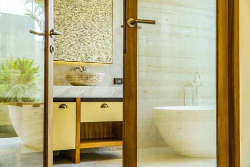 Modern bathroom with wooden accents, a vessel sink, and a standalone bathtub