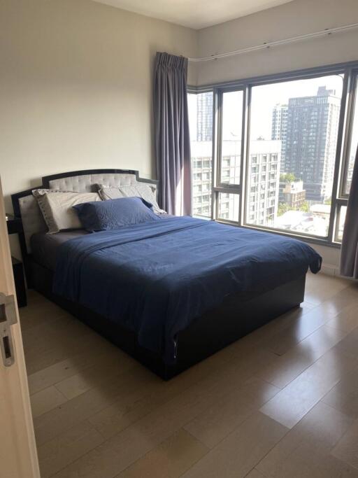 Bedroom with large windows and city view