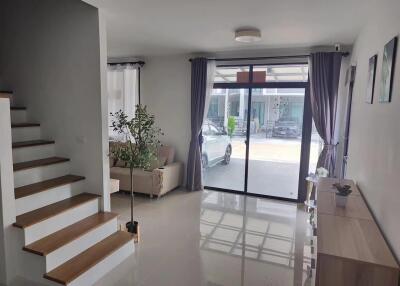 Bright living room with staircase and large sliding glass door