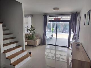 Bright living room with staircase and large sliding glass door