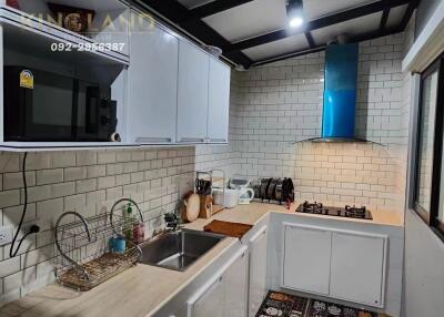 Modern kitchen with white cabinets and blue range hood