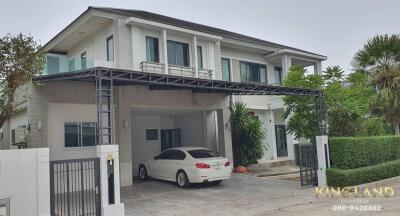 Front exterior view of a two-story house with a car parked in the driveway