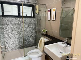 Modern bathroom with glass shower enclosure and mosaic tiles