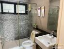 Modern bathroom with glass shower enclosure and mosaic tiles