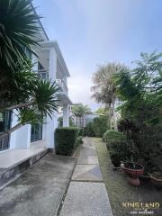 Exterior view of a modern house with a garden and pathway