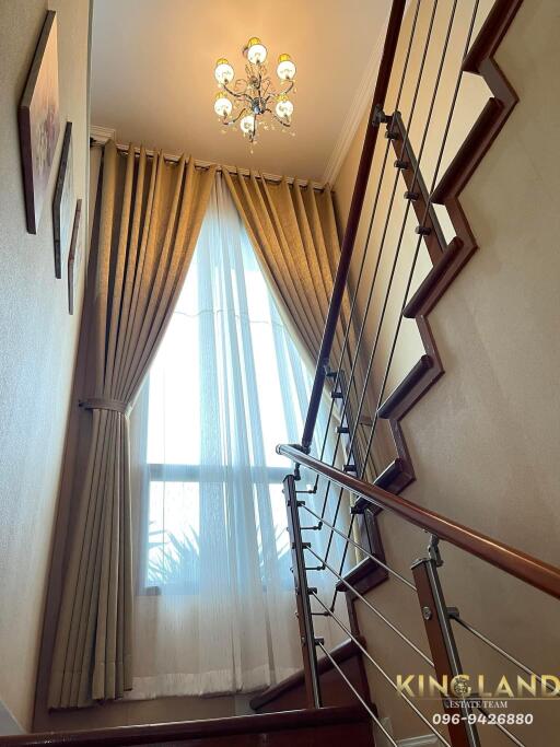 Elegant staircase with chandelier and large window