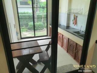 View of the kitchen with dining table and outdoor garden visible