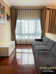 Living room with a large window and modern furniture