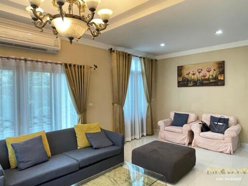 Well-furnished living room with a sofa, armchairs, coffee table, and elegant lighting