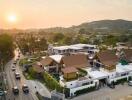 Aerial view of residential area at sunset with modern houses and surrounding landscape