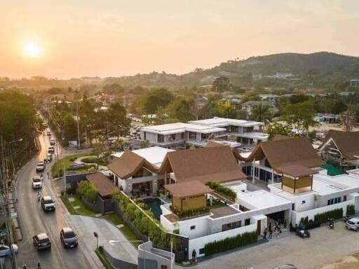 Aerial view of residential area at sunset with modern houses and surrounding landscape