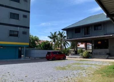 Exterior view of buildings with parked car and gravel driveway