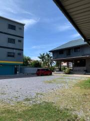 Exterior view of buildings with parked car and gravel driveway